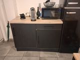 a small kitchen with a microwave, refrigerator, and coffee maker