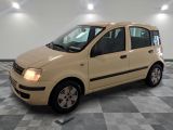 une photo d'une petite voiture beige garée dans un garage