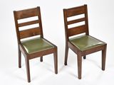 une paire de chaises en bois avec des assises en cuir vert sur fond blanc