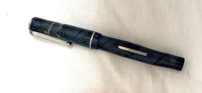 a pen that is laying on a white surface