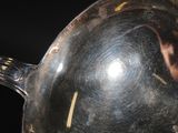 a silver pan with a handle on a black background