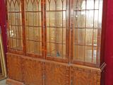 une armoire en bois avec des portes vitrées et un miroir accroché au mur