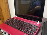 a pink laptop computer sitting on top of a desk