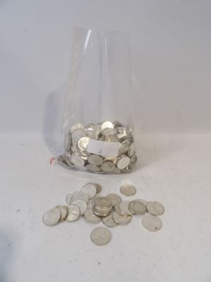 a glass filled with coins sitting on a table