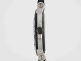 the back of a watch with a black strap on a white surface