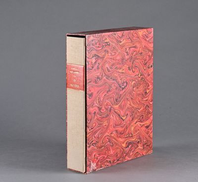 un vieux livre à la couverture rouge posé sur une surface grise