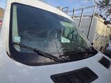 a white van parked in a parking lot with other vehicles