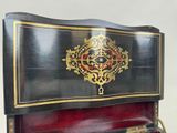 a black and red piano with a gold decoration on it