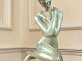 une statue de femme assise sur une table