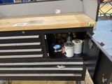 a black tool cabinet with a wooden top in a garage