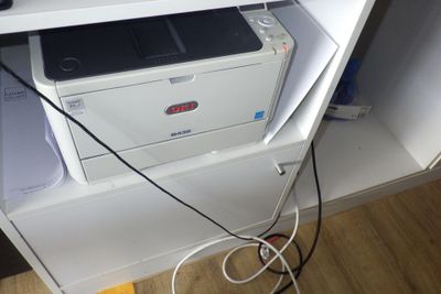 une imprimante blanche posée sur un meuble blanc