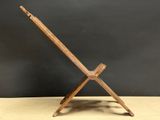 an old wooden folding chair with a wooden seat on a wooden table