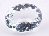 a close up of a faceted blue topazte gemstone on a white surface