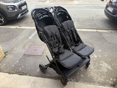 two strollers that are sitting on the side of the street