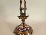 a gold and blue candle holder with two birds on it