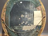 a wooden easel with a round mirror on top of it