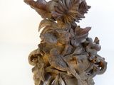 a wooden sculpture of a bird with flowers on it