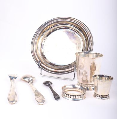 un plateau en argent, ainsi que des tasses et des cuillères en argent, posés sur une table