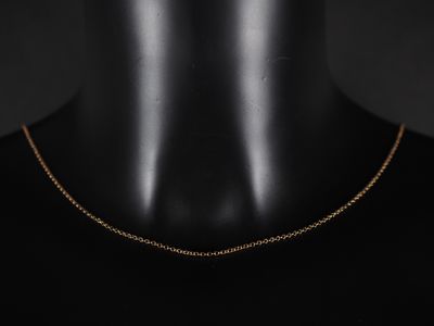 un collier à chaîne en or avec un pendentif de forme carrée autour du cou d'un mannequin