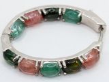 silver bracelet with multi colored stones on a white surface