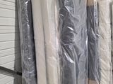 many mattresses wrapped up in plastic in a warehouse