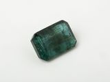 a green emerald stone on a white surface