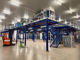 a large warehouse with a lot of shelves and stairs