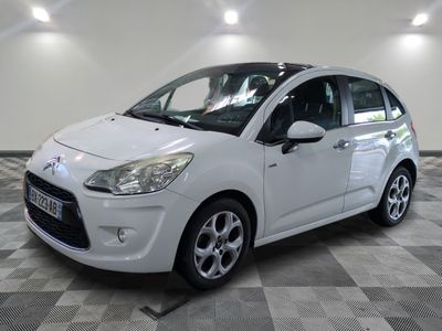 the small white car is parked on a checkered floor