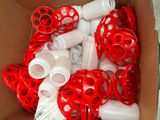 a box full of red and white plastic pipes and fittings