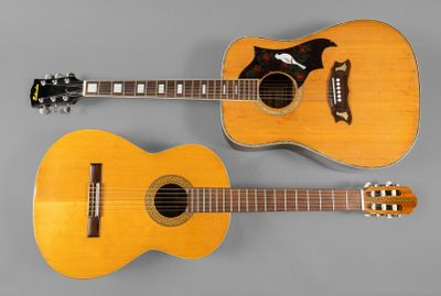 deux guitares acoustiques posées côte à côte sur une surface grise