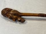 a wooden stick with a carved head on it