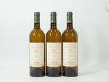 trois bouteilles de vin posées les unes à côté des autres sur une surface blanche