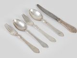 six spoons, forks and a knife on a white surface