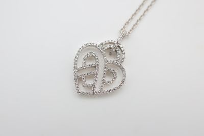 un pendentif en or blanc en forme de cœur, serti de diamants, monté sur une chaîne