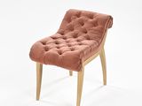 chaise rose avec des pieds en bois et un coussin capitonné, sur fond blanc