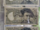 three bank notes on display in a glass case