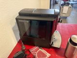 a microwave sitting on a red table next to a coffee cup