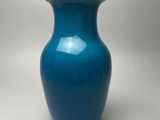 a blue vase that is sitting on a table