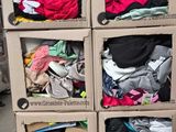 un chariot sur lequel sont empilées de nombreuses boîtes de vêtements