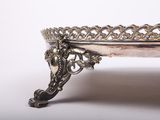 an antique silver plate with a decorative design on it