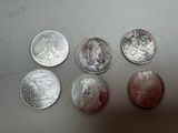 six different coins sitting on top of a table next to each other