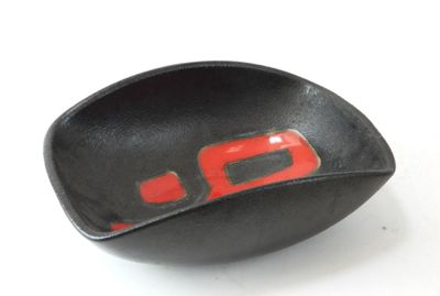 un bol noir orné d'un motif rouge à l'intérieur