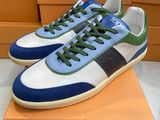 une paire de baskets bleues et vertes posées sur une boîte