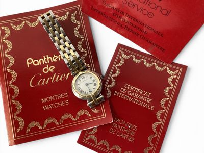 un livre rouge sur lequel figure une montre en or et un livre rouge sur lequel figure une montre en or
