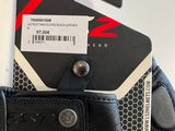 the back of a pair of black leather gloves with a tag on it