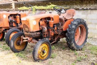 un vieux tracteur qui est à l'abandon dans l'herbe