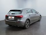 the rear end of a silver car in a white room