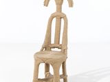 une petite chaise en paille dont le dossier est orné d'une tête de chèvre