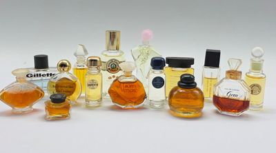 Plusieurs flacons de parfum sont alignés sur une surface blanche