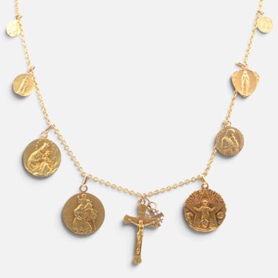 a close up of a gold necklace with a cross on it